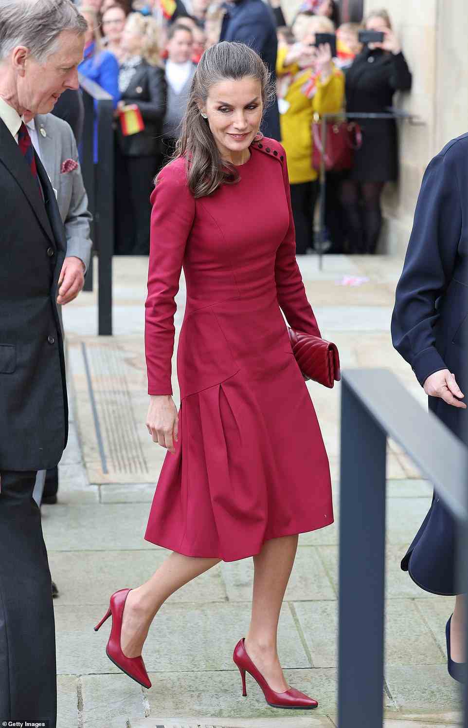 The mother-of-two cut an elegant figure in a raspberry red dress for the outing, which she paired with matching accessories (pictured)