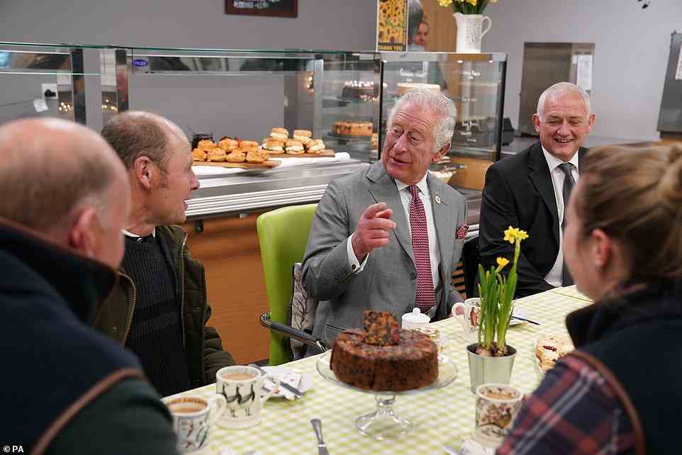 Prince Charles 73, was snapped in a jovial mood as he laughed with a group of people while enjoying tea and cake