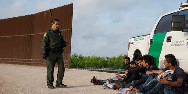 Ein Grenzschutzbeamter nimmt am Montag, den 26. März 2018, im Sektor Rio Grande Valley in der Nähe von McAllen, Texas, illegale Einwanderer fest, kurz nachdem sie die Grenze von Mexiko in die Vereinigten Staaten überschritten haben.