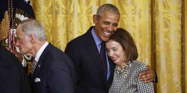 WASHINGTON, DC – 5. APRIL: Der ehemalige Präsident Barack Obama umarmt die Sprecherin des Repräsentantenhauses Nancy Pelosi (D-Calif.) am Ende einer Veranstaltung anlässlich der Verabschiedung des Affordable Care Act 2010 im East Room des Weißen Hauses am April 5, 2022. 