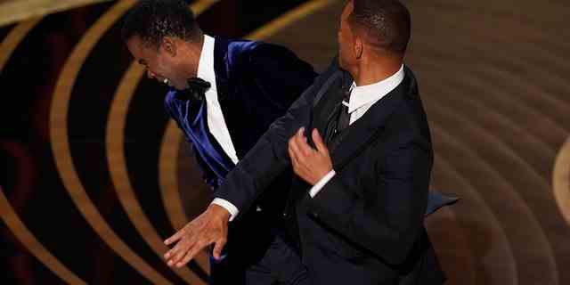 Will Smith trifft Moderator Chris Rock auf der Bühne, während Rock den Preis für den besten Dokumentarfilm bei den Oscars überreicht.