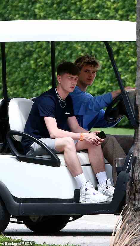 Driving: Cruz was joined by a friend as they rode the club cart around the sprawling estate
