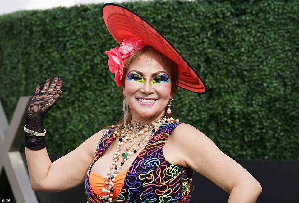 While many racegoers opted to wear muted, pastel tones, this lady chose to sport a more eye-catching look, wearing a plethora of neon tones, topped with a scarlet hat