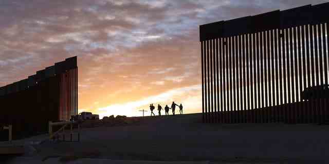 10. Juni 2021: Zwei Migrantenfamilien aus Brasilien passieren eine Lücke in der Grenzmauer, um die Vereinigten Staaten zu erreichen, nachdem sie von Mexiko nach Yuma, Arizona, gereist sind, um Asyl zu beantragen.   