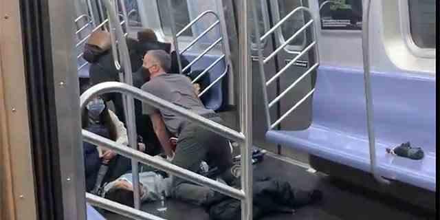 Eine Person wird am Dienstag, den 12. April 2022 in einem U-Bahn-Wagen in Brooklyn, New York, versorgt.