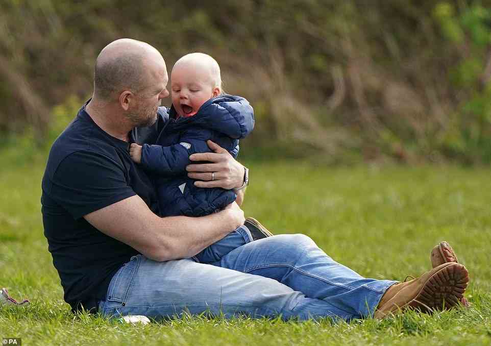 Lächeln für Papa!  Baby Lucas Tindall, der letzten Monat ein Jahr alt wurde, sah begeistert aus, in den Armen seines Vaters Mike zu liegen