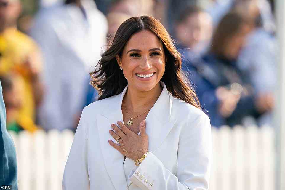 A warm welcome: Meghan is all smiles for the crowd as they arrive at the welcome event