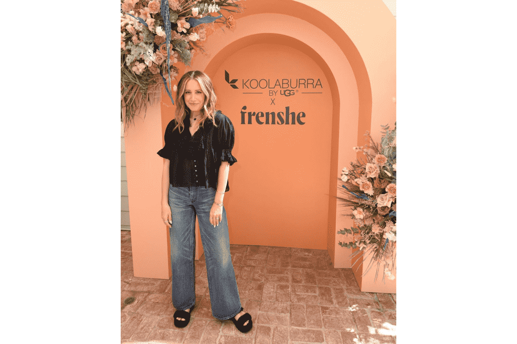 Ashley Tisdale neben einem Schild von Koolaburra by UGG und Freshne