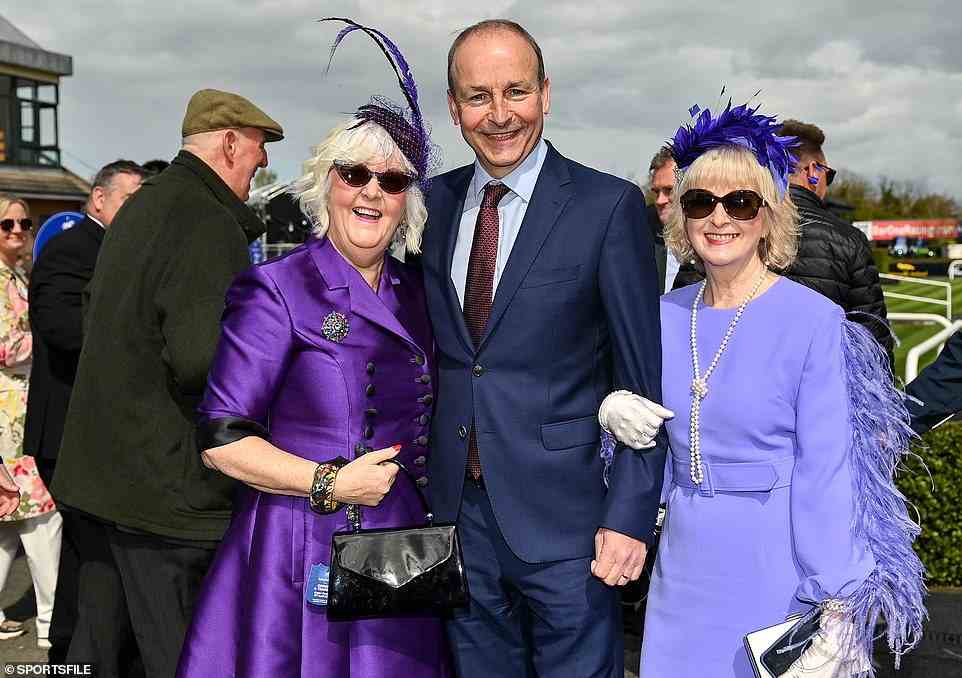 Damen in Lavendel: Der irische Premierminister Micheal Martin mischt sich bei Sonnenschein unter zwei sehr glamouröse Zuschauer