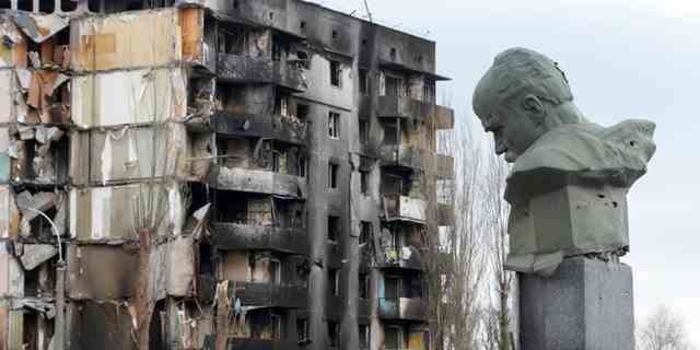 Ein Denkmal für Taras Shevchenko, einen ukrainischen Dichter und ein nationales Symbol, ist mit Spuren von Kugeln vor dem Hintergrund eines Wohnhauses zu sehen, das durch den russischen Beschuss auf dem zentralen Platz in Borodyanka, Ukraine, zerstört wurde, Mittwoch, 6. April 2022. 