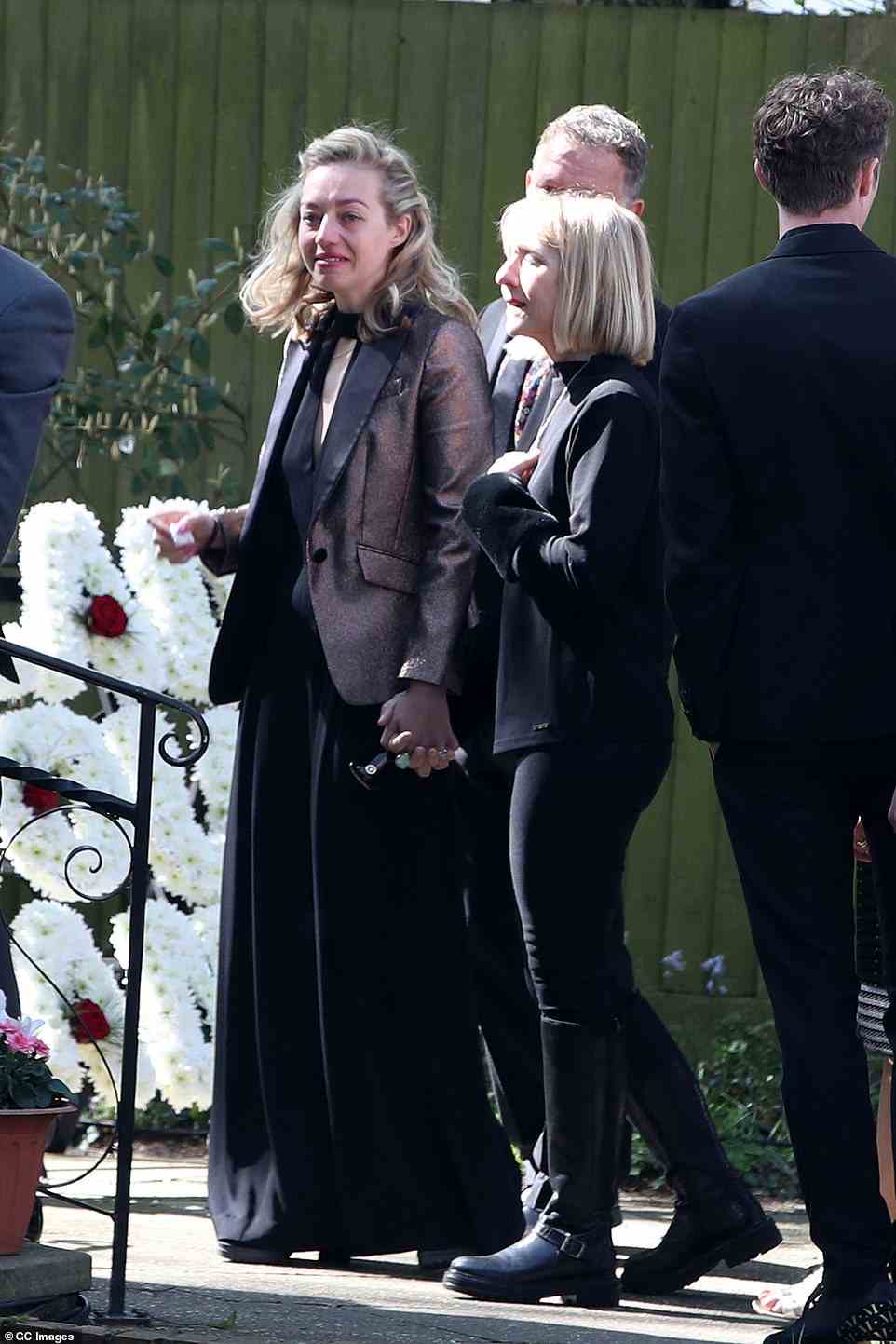Showbiz sparkle: Kelsey wore a flowing black jumpsuit  under a sparkling tuxedo jacket as mourners dressed in black