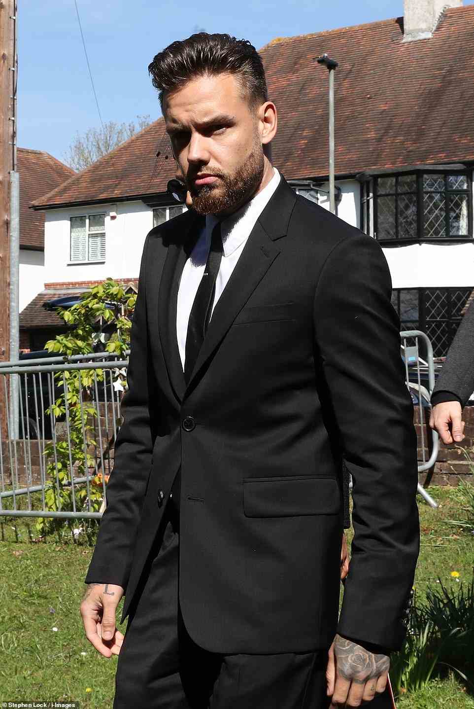 Friend: The singer dressed in a black suit and tie for the funeral, pictured arriving for the service