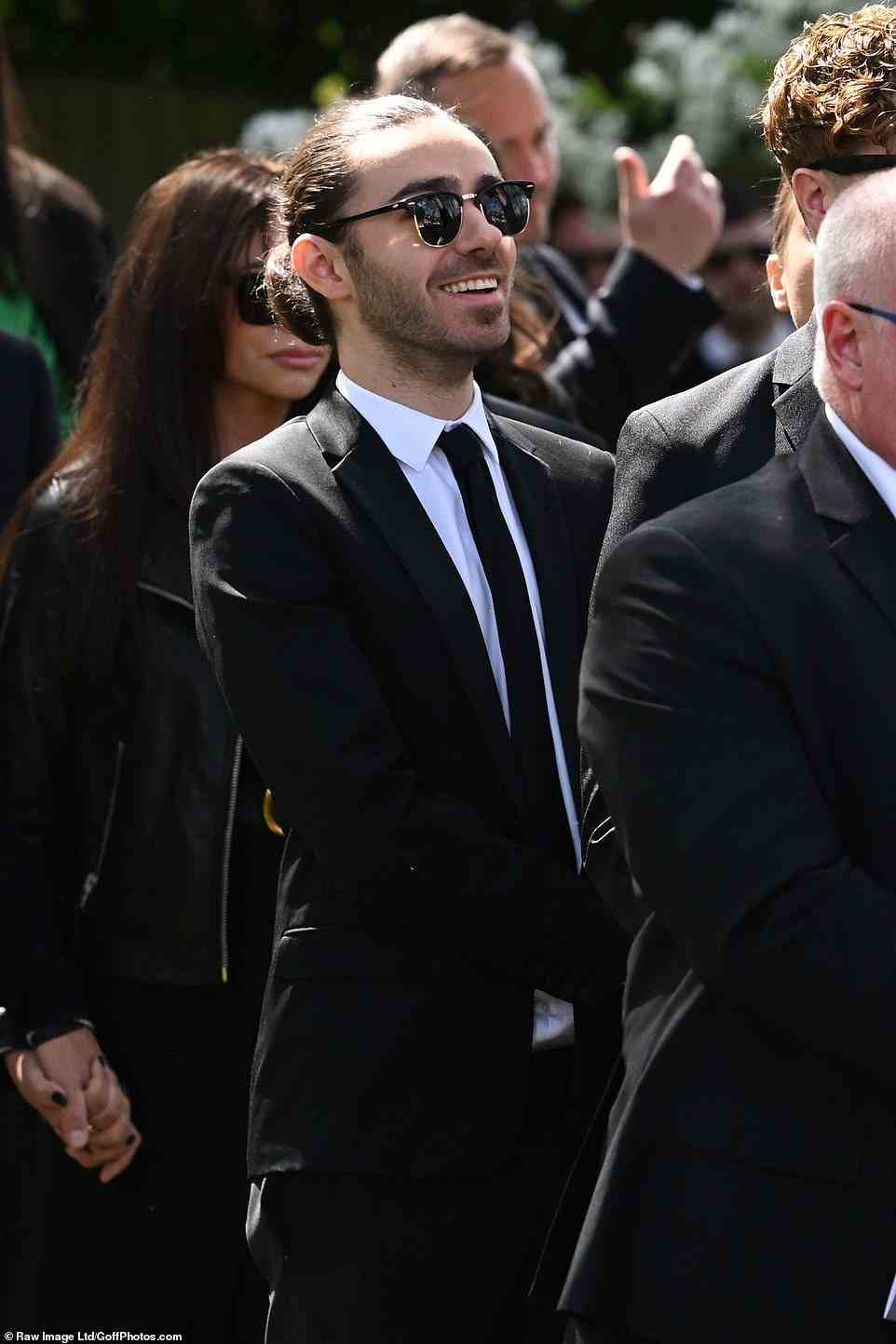 Laughter and tears: Nathan was seen smiling as the band shared memories with Tom's family and friends