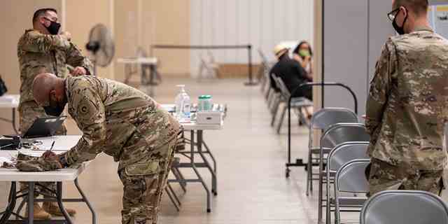 Soldaten reichen Papierkram ein, bevor ihnen am 9. September 2021 in Fort Knox, Kentucky, ihre COVID-19-Impfungen vom präventiven medizinischen Dienst der Armee verabreicht werden.