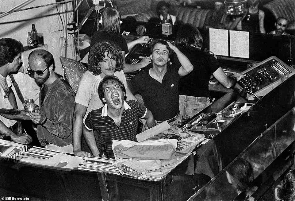 1979 im Studio 54 abgebildet, können wir uns nur vorstellen, dass dieser Mann nach mehr schreit, während er sich über die Platten in Richtung Kamera beugt.  Sein Freund sieht jedoch etwas verwirrt aus