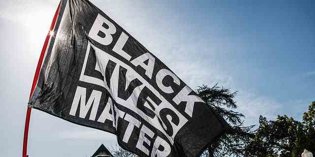 Ein Demonstrant schwenkt während der Demonstration in Los Angeles, Kalifornien, eine Flagge der Black Lives Matter (BLM).