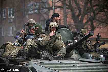 Service members of pro-Russian troops are seen atop of an armoured vehicle during Ukraine-Russia conflict in the southern port city of Mariupol