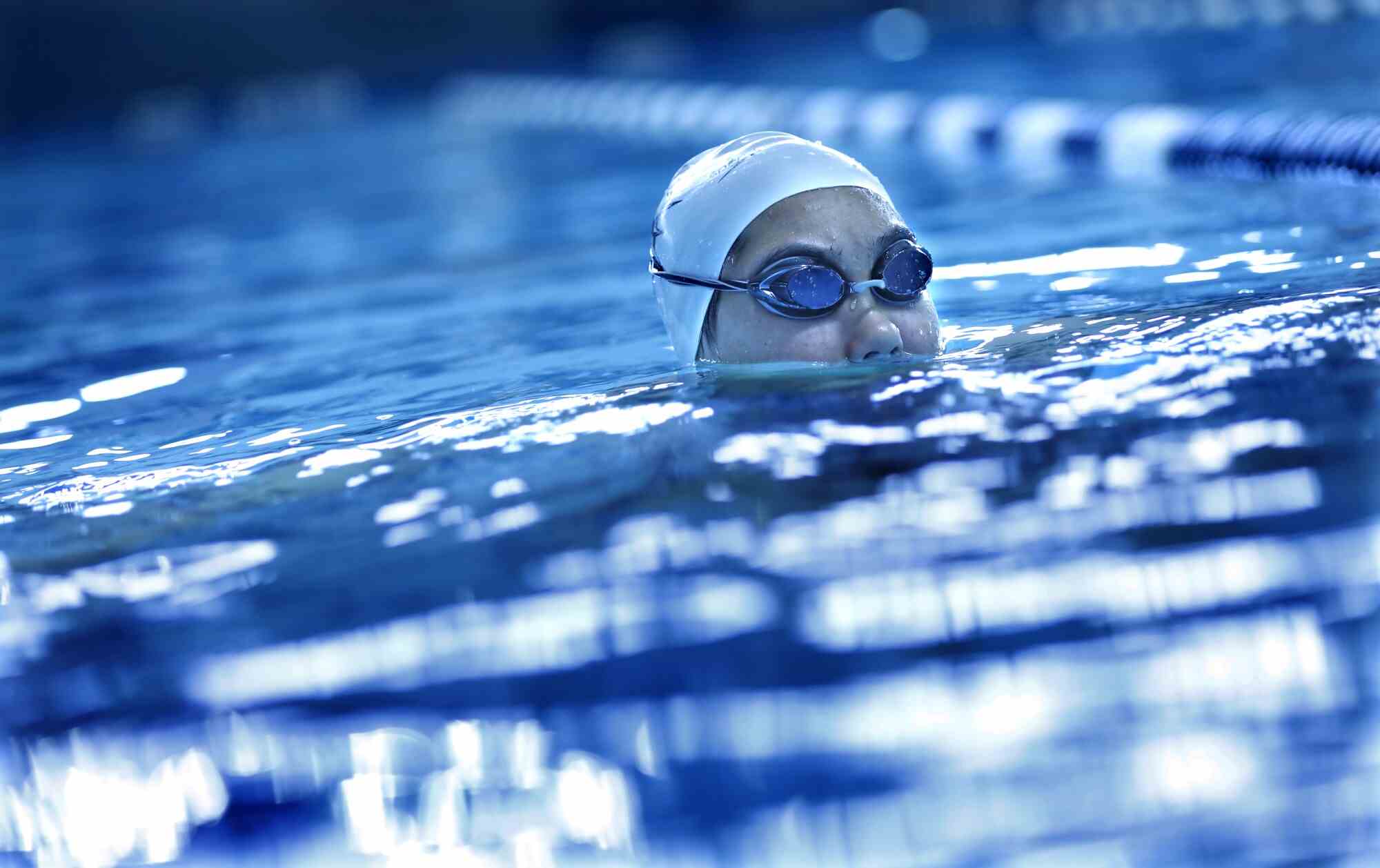 Kayla Hans Kopf mit Schwimmkappe und Schutzbrille befindet sich in einem Pool meistens über Wasser.