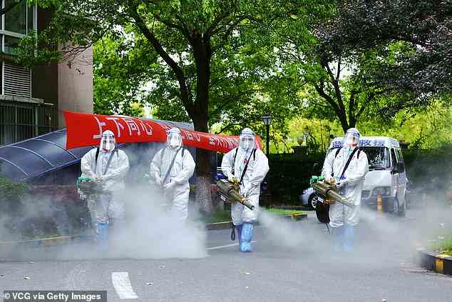 Members of the 'Blue Sky Rescue Team' disinfect a residential community during the phased lockdown triggered by the COVID-19 outbreak on April 24, 2022 in Shanghai, China