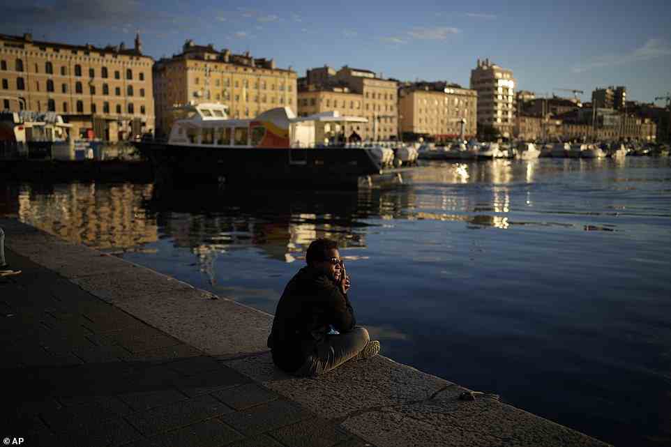 Ein Mann beobachtet kurz vor dem Ende der Abstimmung vom alten Hafen von Marseille aus den Sonnenuntergang