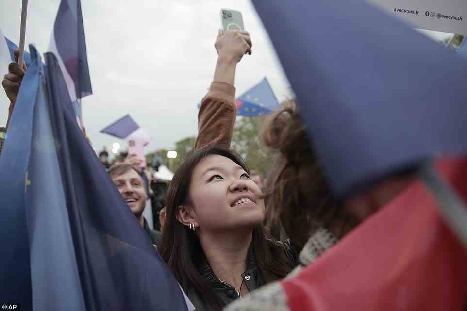 Ein Unterstützer von Macron feiert am Sonntag Berichte über seinen Sieg
