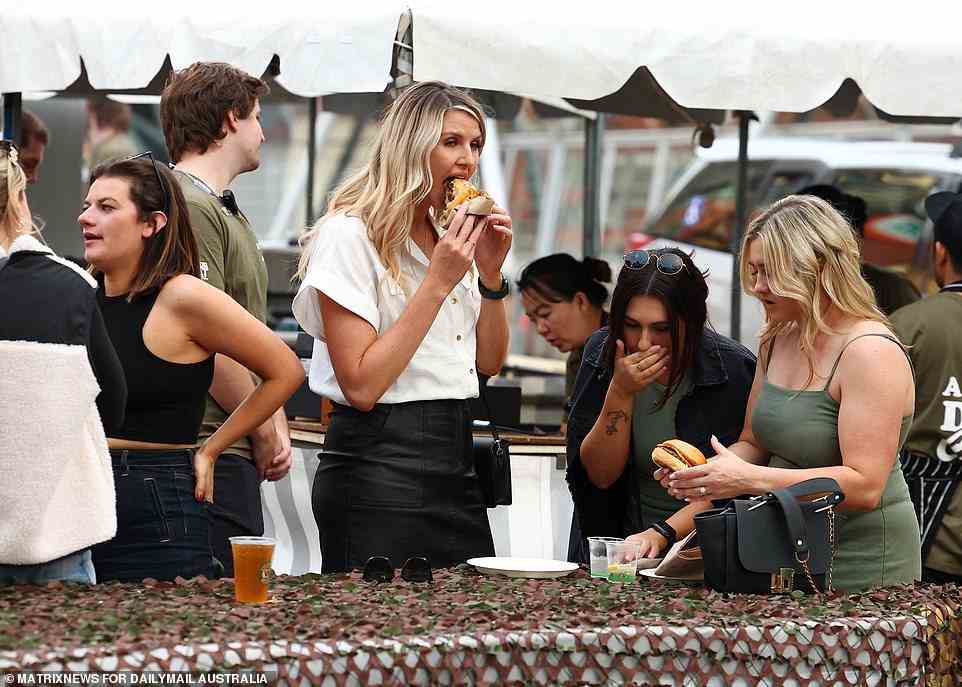 A group of women feast on some burgers as they enjoy some drinks at a bar in the city for the public holiday