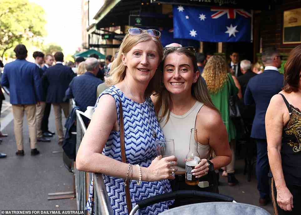 Two women pose for a photo as they enjoy some glasses of beer in a packed bar in The Rocks on Monday