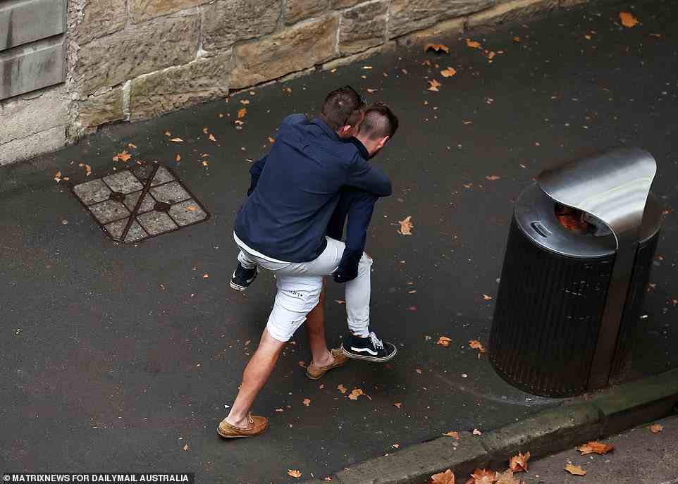 A man gives his mate a piggy back ride as they leave a venue in The Rocks on Monday