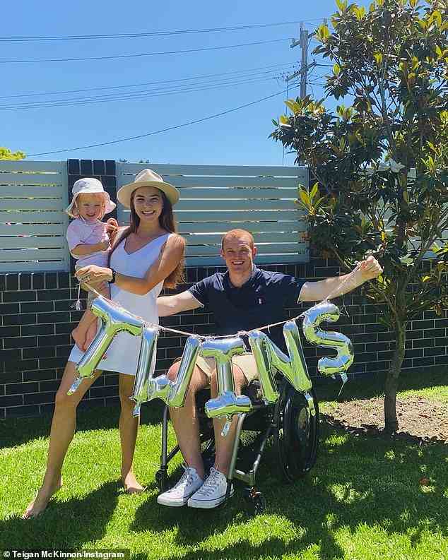 Teigan McKinnon (pictured centre, holding daughter Harriet) and Alex McKinnon (right) when they announced she was pregnant with twins