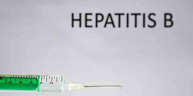 Diese Fotoillustration zeigt eine Einwegspritze mit Injektionsnadel, HEPATITIS B, geschrieben auf einer weißen Tafel dahinter.