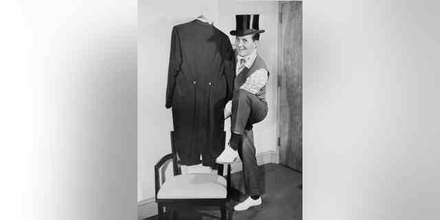 Pat Boone stellt am 30. Oktober 1958 in New York seinen Zylinder, seine weiße Krawatte und seinen Frack zur Schau, als er sich auf eine Reise nach London vorbereitete, um eine Aufführung des königlichen Kommandos für Königin Elizabeth II. zu leiten.