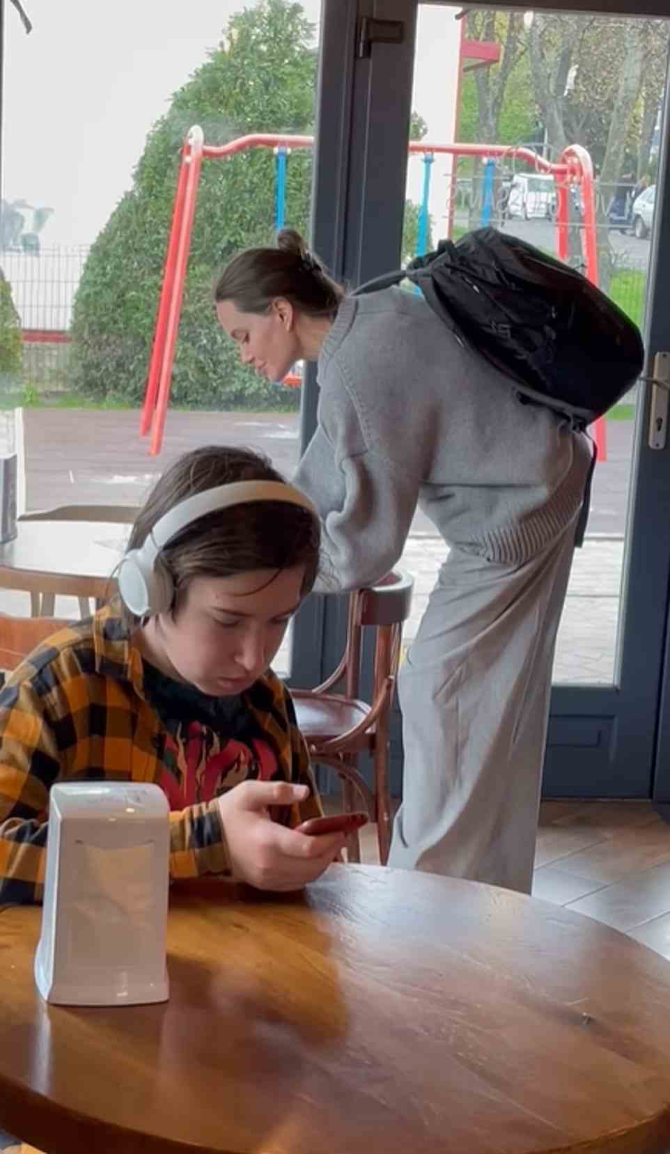 Die Schauspielerin Angelina Jolie überraschte die Ukrainer, nachdem sie in einem Café in Lemberg aufgetaucht war.  Ein Junge an seinem Telefon bemerkte die weltberühmte Schauspielerin nicht, als sie hinter ihm in das Café kam