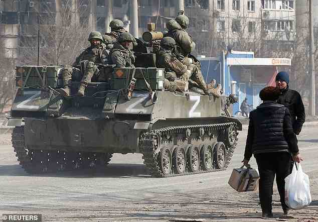 Harte Zeiten: In der belagerten südlichen Hafenstadt Mariupol fahren prorussische Truppen auf einem gepanzerten Fahrzeug an Bürgern vorbei