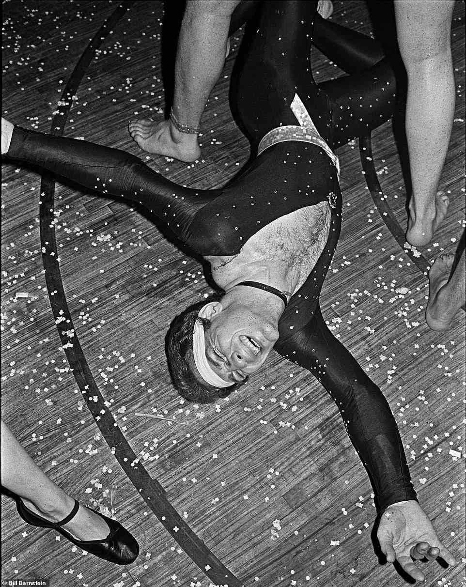 Das ist ein Saturday Night Fever!  Ein Mann in einem Catsuit beugte sich 1979 in Le Clique nach hinten, während die Frau neben ihm in Ballettschuhen ihre Zehen zeigt