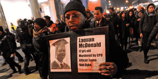 Auf diesem Aktenfoto vom 24. November 2015 hält ein Mann ein Schild mit einem Foto von Laquan McDonald darauf, während eines Protestes gegen die Erschießung des 17-jährigen McDonald durch die Polizei in Chicago. 
