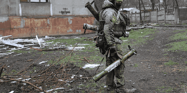 Ein bewaffneter Soldat der Miliz der Volksrepublik Donezk geht am Mittwoch an einem Gebäude vorbei, das während der Kämpfe in Mariupol beschädigt wurde.