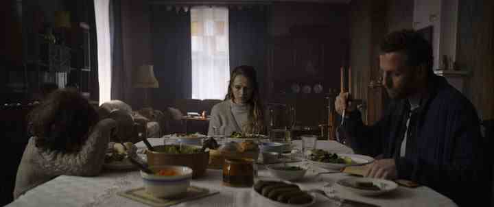 Elliot, Anthony und Rachel sitzen alle um den Tisch in einer Szene aus The Twin.