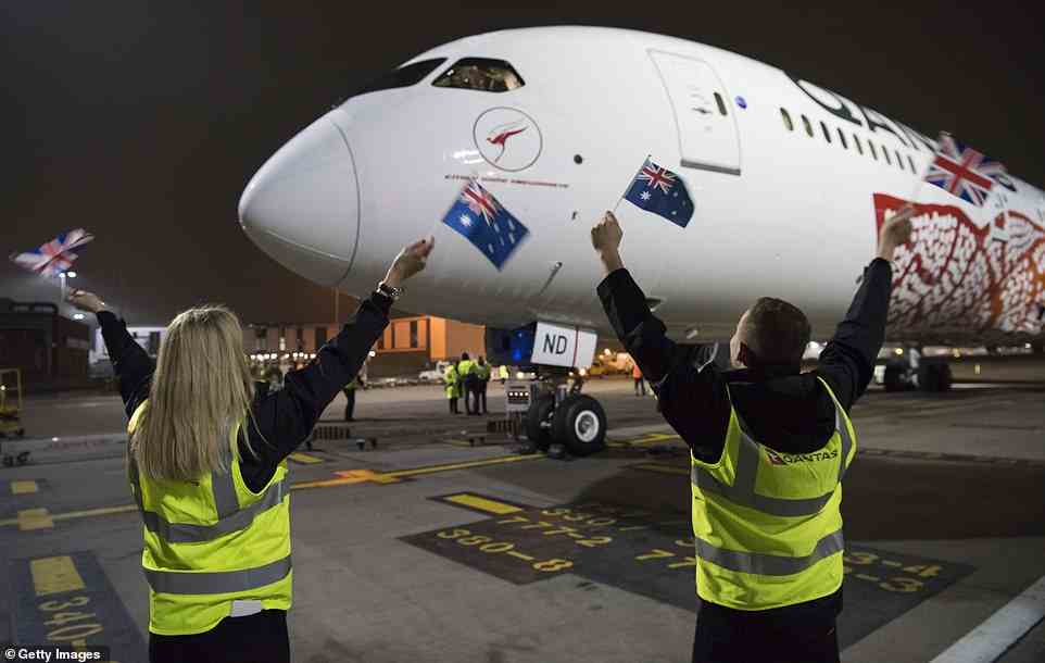 Qantas staff wave Australian and British flags at the Boeing 787 Dreamliner after landing at Heathrow Airport on March 25, 2018, following a historic direct flight from Perth