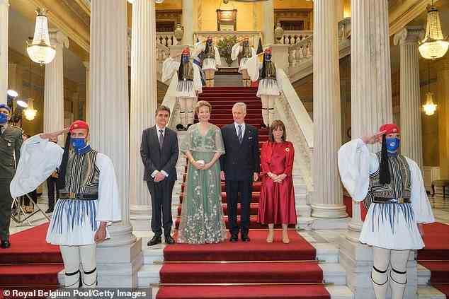 Herr Pavlos Kotsonis, König Philippe, Königin Mathilde und die griechische Präsidentin Katerina Sakellaropoulou posieren während der Begrüßungszeremonie umgeben von Wachen in traditioneller Uniform