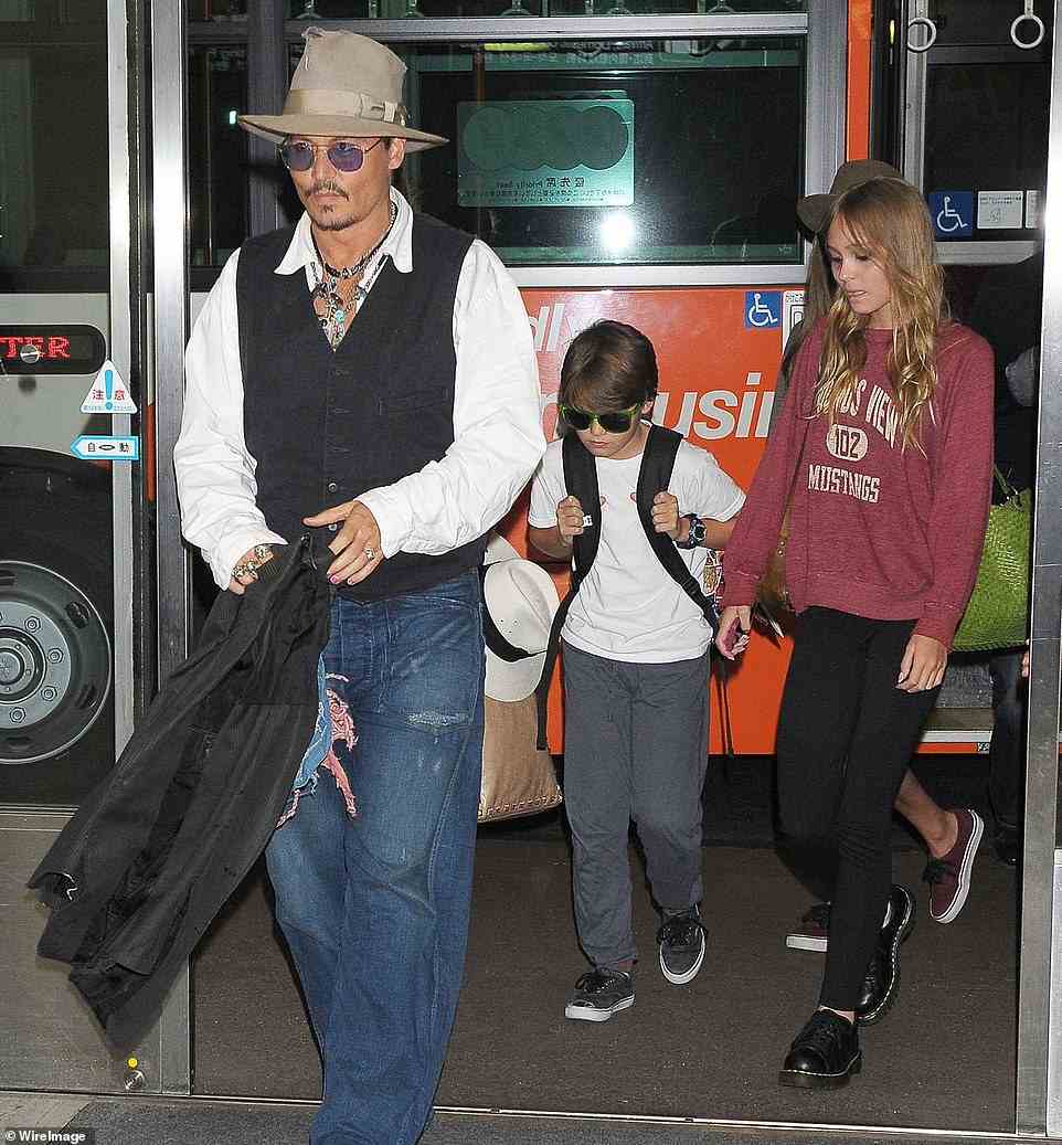Heard told the court that Depp was drinking but 'didn't want to tell his kids so he was hiding it from them, putting it in coffee cups and drinking it.' Depp and his children are pictured in 2013