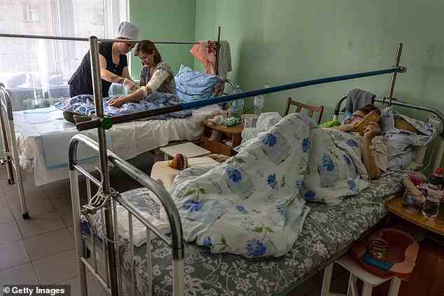 Eine Krankenschwester untersucht die Wunden von Ponomareva Natalia Sergiivna, 41, drei Tage nachdem das Haus ihrer Familie am Donnerstag von russischen Streitkräften in ihrem Frontdorf Vysokopilla in der Region Cherson in der Südukraine beschossen wurde