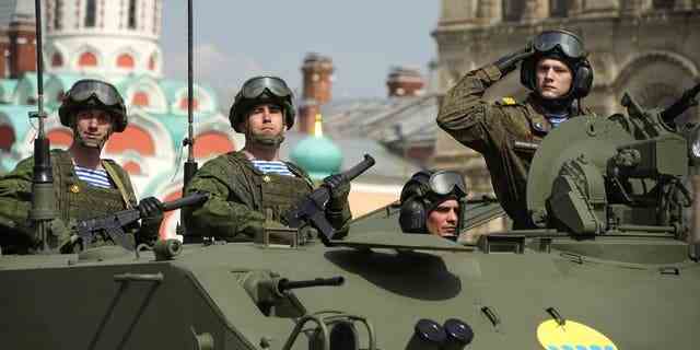 Soldaten der russischen Armee stehen in einem Militärfahrzeug, das während einer Generalprobe für die Militärparade zum Tag des Sieges in Moskau, Russland, Samstag, 7. Mai 2022, rollt. Die Parade findet am 9. Mai auf dem Roten Platz in Moskau statt, um 77 Jahre des Sieges zu feiern im Zweiten Weltkrieg. 