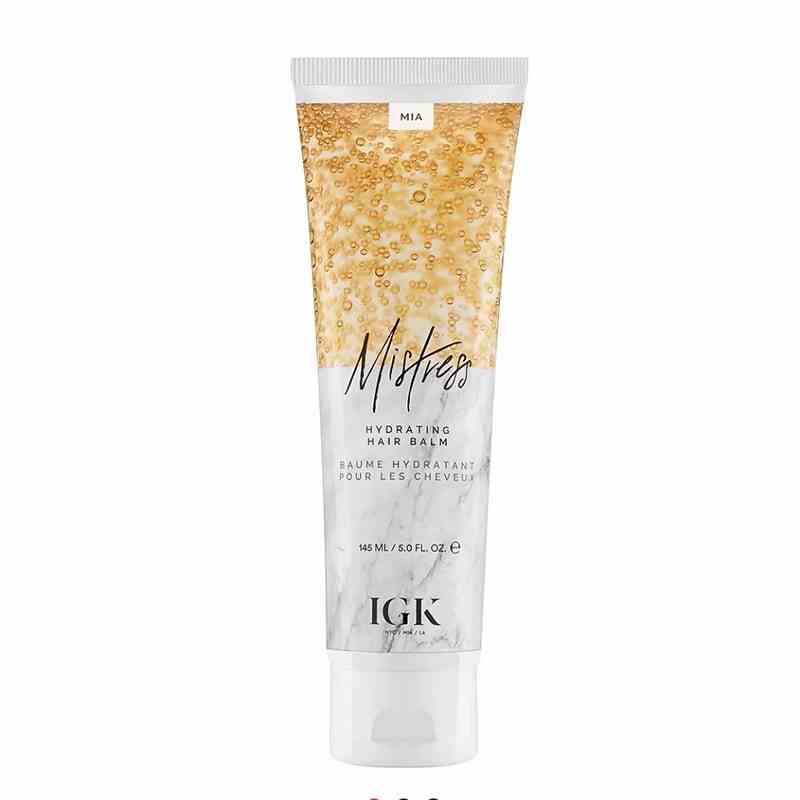 A gold and white bottle of the IGK Haircare Mistress Hydrating Hair Balm