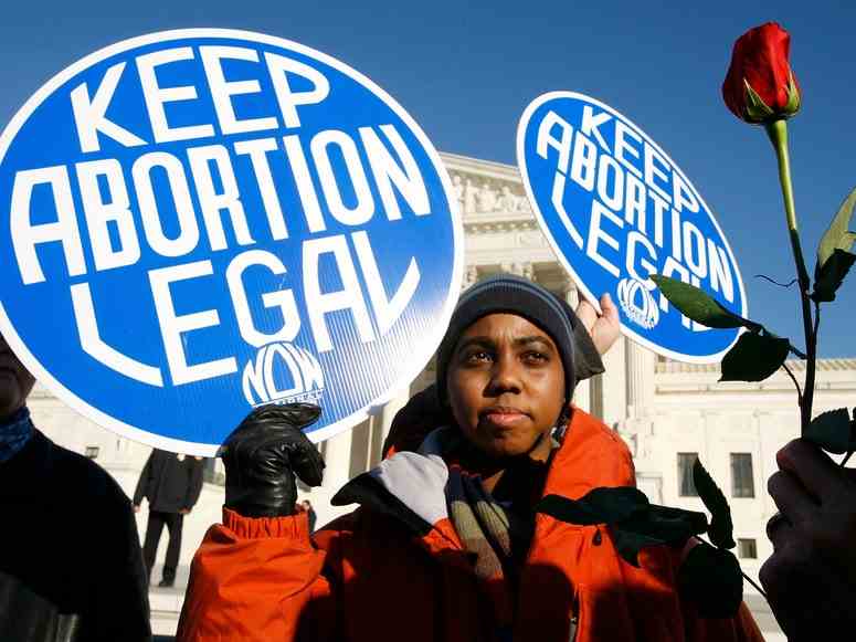 Eine Person, die vor dem Obersten Gerichtshof der Vereinigten Staaten ein Schild mit der Aufschrift hält "Abtreibung legal halten."