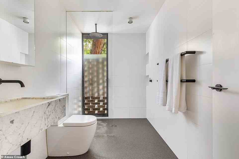 Es gibt auch das luxuriöse Badezimmer mit Marmordetails und einem schmalen Milchglasfenster neben der Regendusche, um Privatsphäre zu gewährleisten