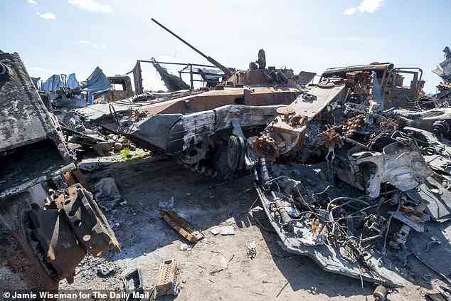 Pictured: The wreckage of a Russian tank is seen amongst the twisted metal of other destroyed Russian military vehicles in Bucha, UKraine