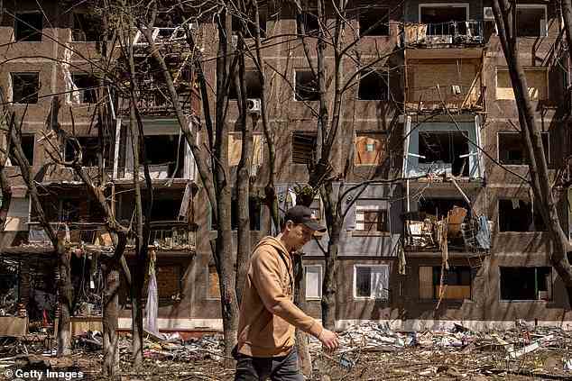A man walks past a residential apartment block damaged one day before by a Russian missile strike on May 06, 2022 in Kramatorsk, eastern Ukraine