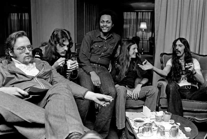 Fünf Jungs einer Rockband sitzen in einem Hotelzimmer