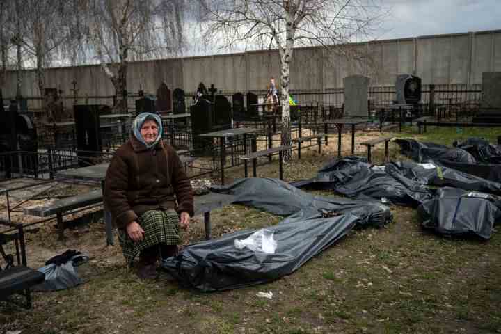Nadiya Trubchaninova, 70, sitzt neben einer Plastiktüte, die die Leiche ihres Sohnes Vadym Trubchaninov, 48, enthält, der am 30. März 2022 von russischen Soldaten in Bucha am Stadtrand von Kiew, Ukraine, getötet wurde.