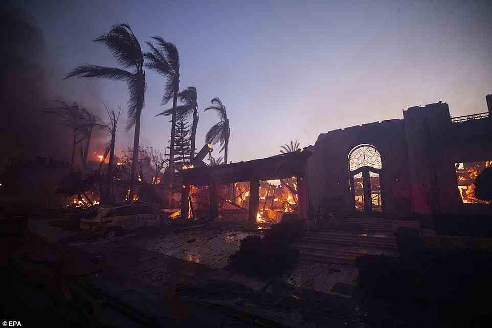 A mansion and a car are seen destroyed by the raging wildfire in Laguna Niguel on Wednesday